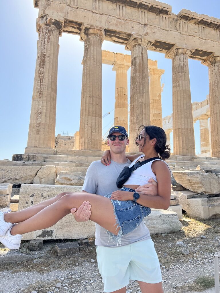 Ryan carrying Maddie in front of the Parthenon in Athens
