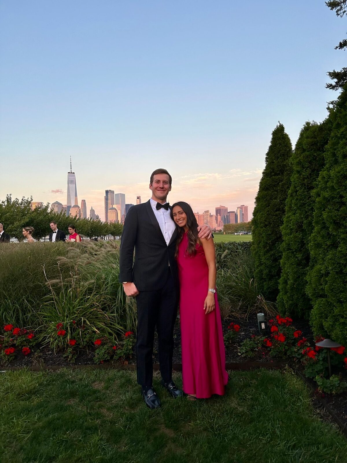 The couple dressed for a black-tie evening, the lower Manhattan skyline at dusk behind them