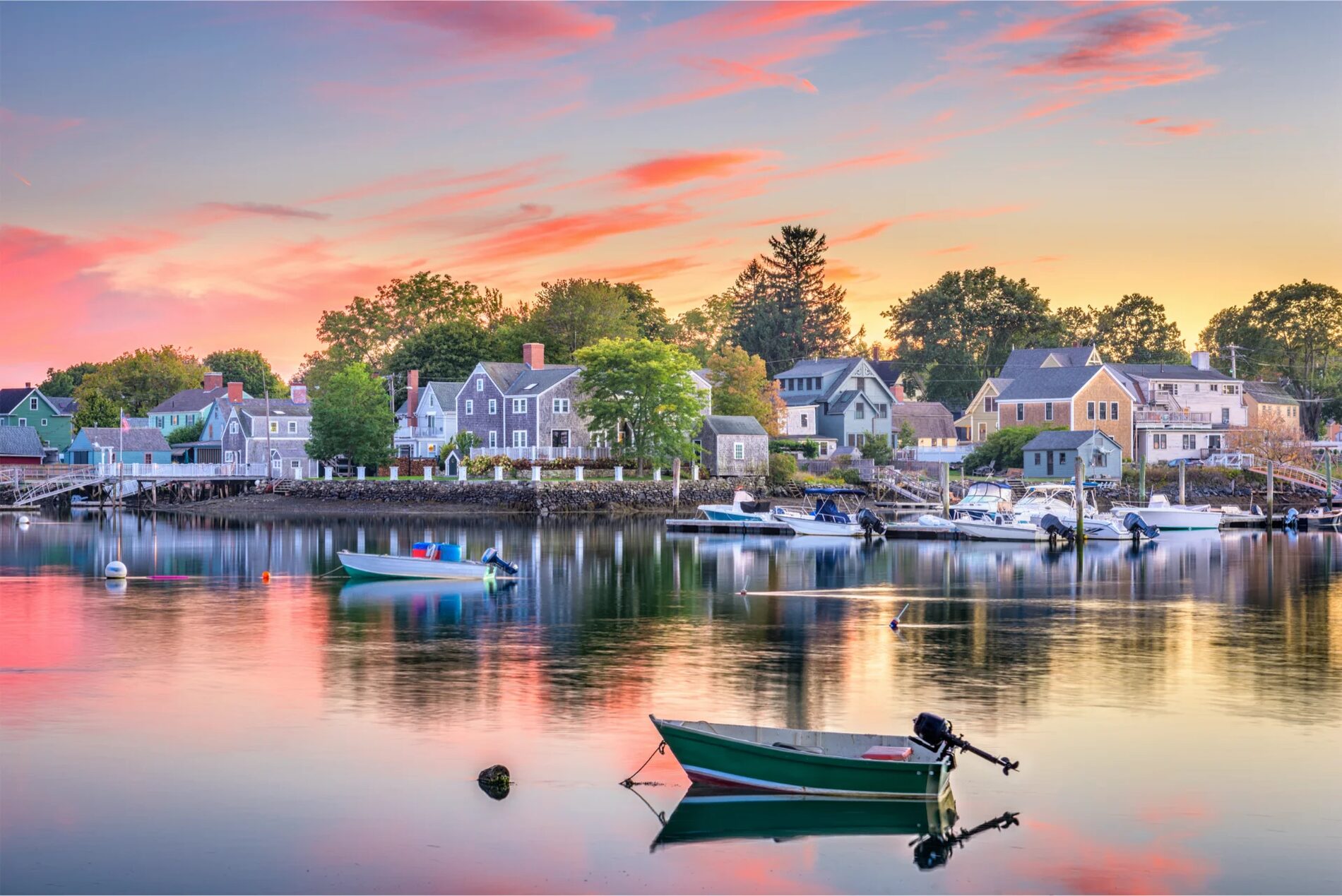 Shingled houses and small boats along Portsmouth's South End waterfront under a pink sunset sky