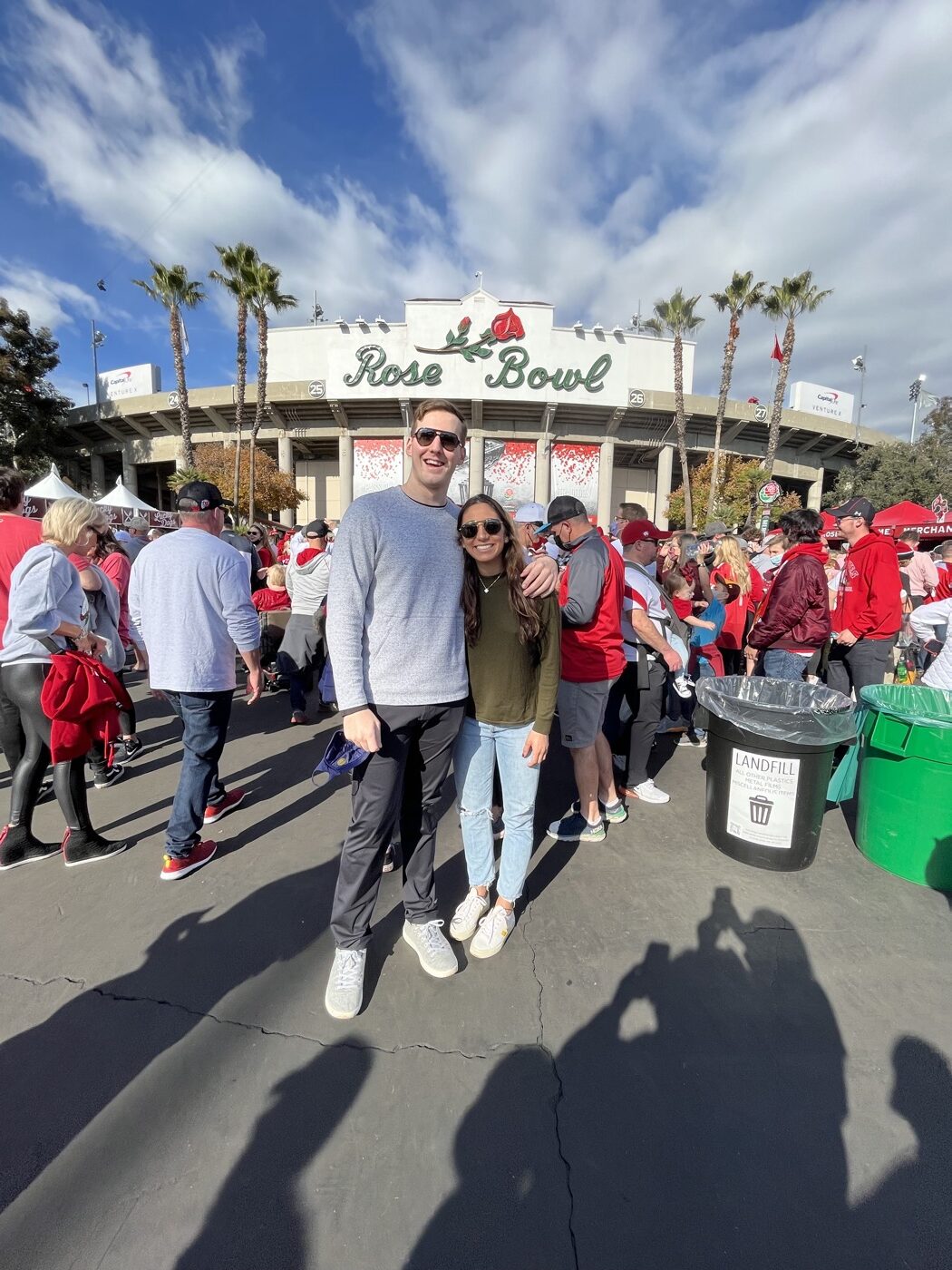 The couple smiling in the crowd outside the Rose Bowl stadium